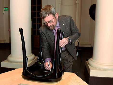J. Michael Kosterlitz autographs a chair